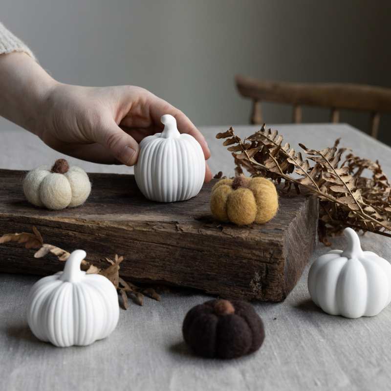 Herbstdekoration in Form verschiedener Kürbisse aus Keramik