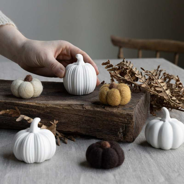 Herbstdekoration in Form verschiedener Kürbisse aus Keramik
